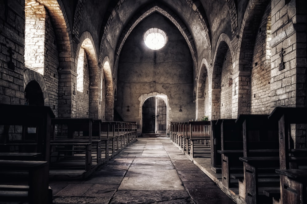 an empty church with pews and a bright window