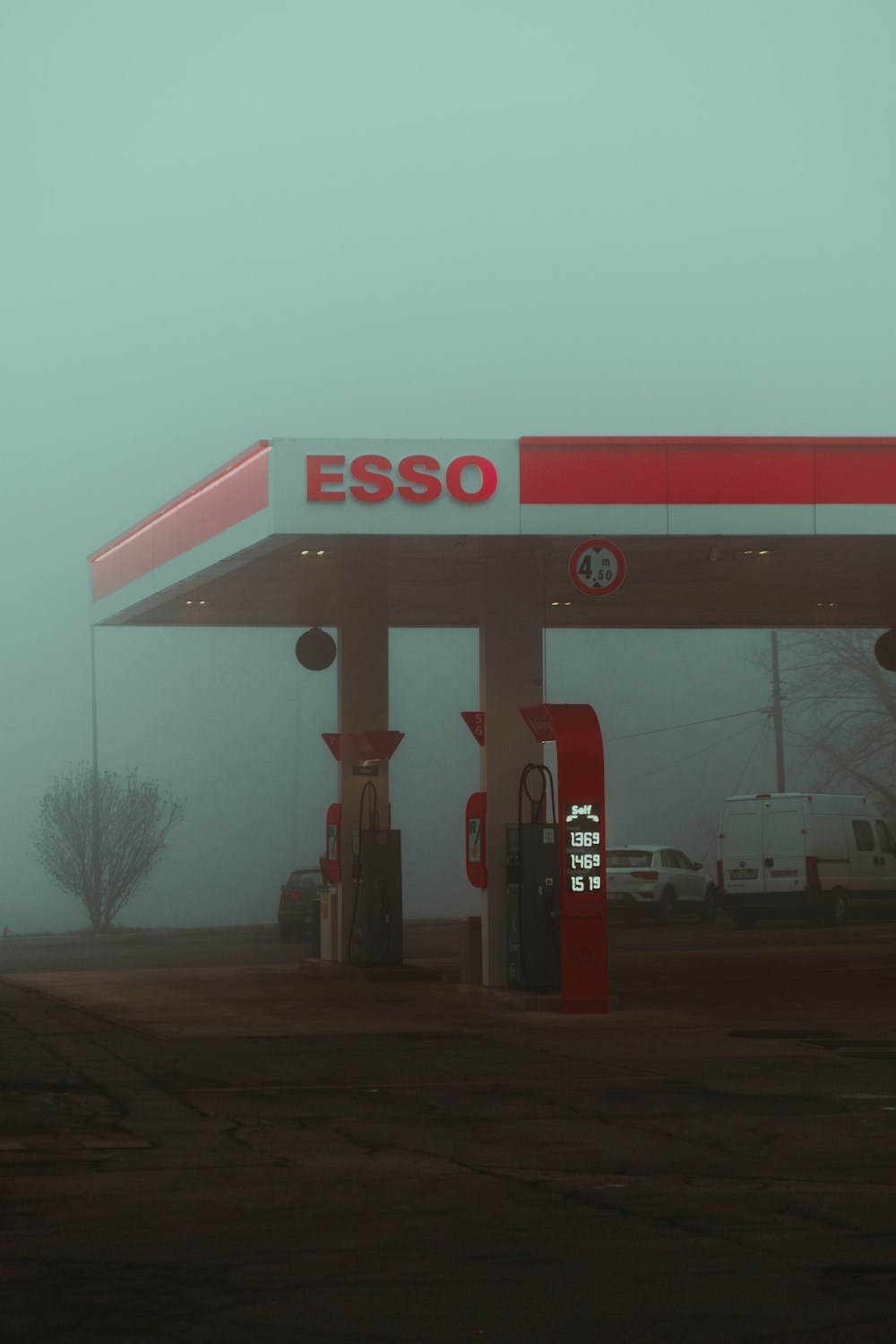 a red and white gas station on a foggy day