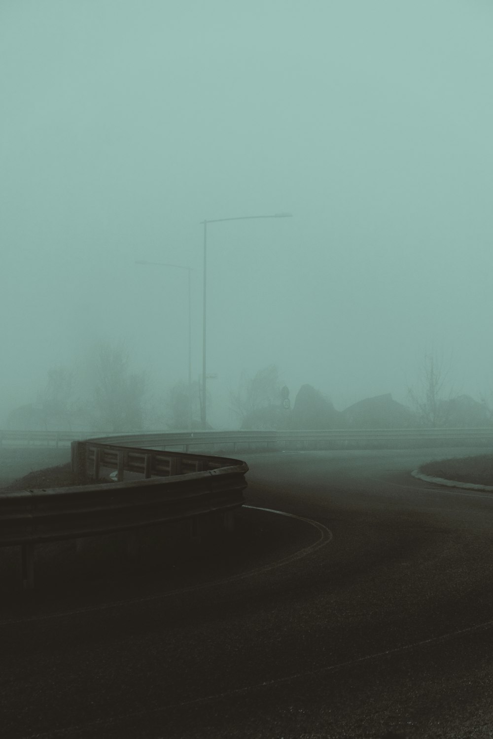 a foggy road with a stop sign in the middle