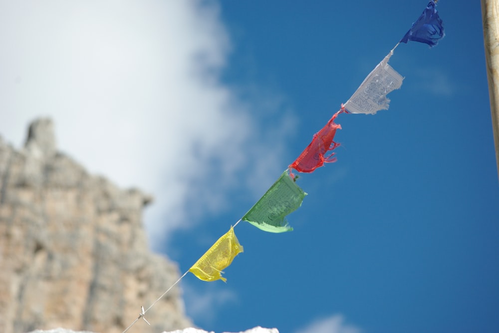 a group of colorful flags hanging from a wooden pole