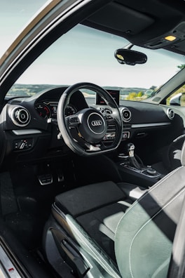the interior of a car with a steering wheel and dashboard