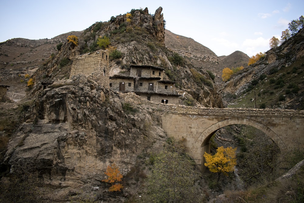 a stone bridge over a river next to a mountain