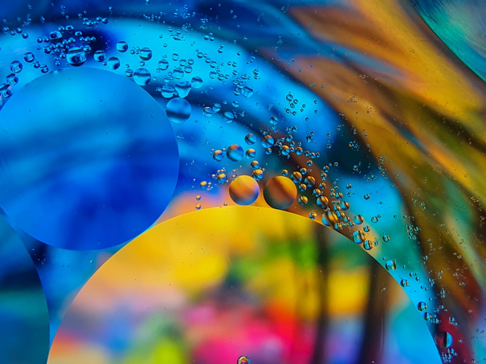 a close up of water droplets on a colorful background