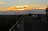 Truck loaded with diverse cargo on a highway at sunset.