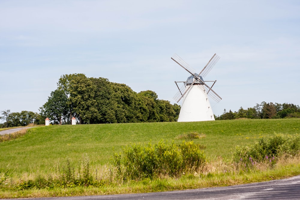 a windmill in the middle of a grassy field