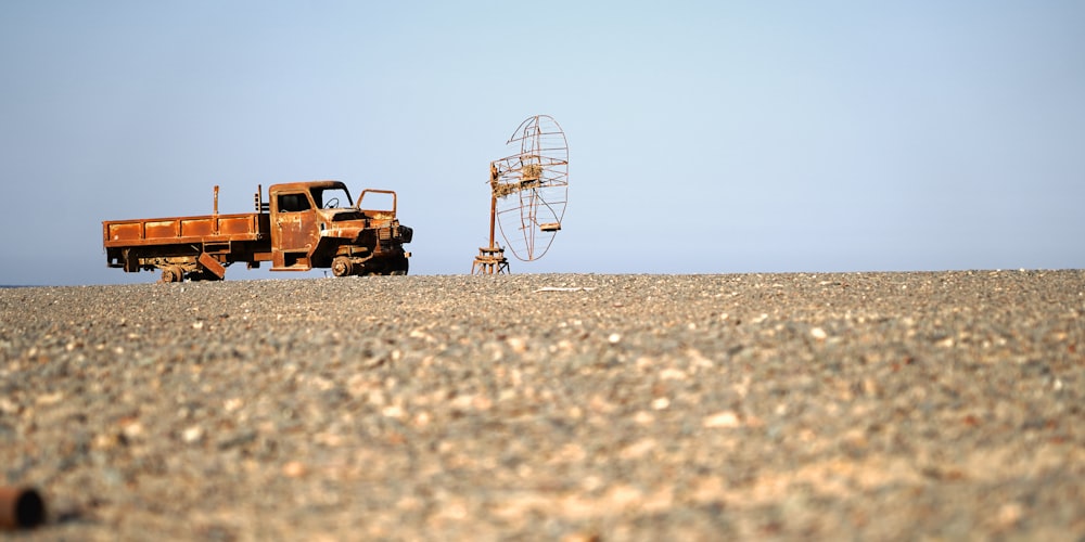 a rusted out truck sitting in the middle of a field