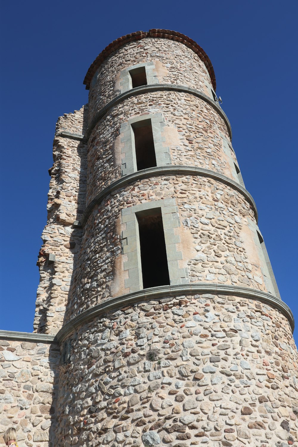 uma torre de tijolos alta com um relógio de lado
