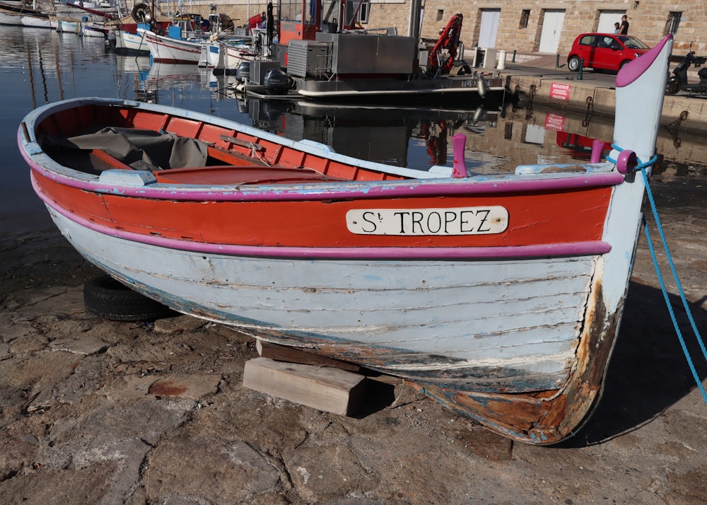 a red and white boat sitting on top of a body of water