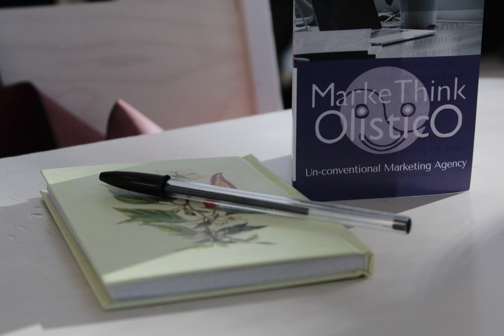 a pen sitting on top of a book on a table