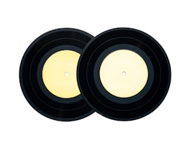 Two black vinyl records with light yellow labels placed side by side against a white background.