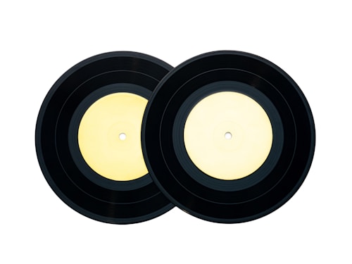 Two black vinyl records with light yellow labels placed side by side against a white background.