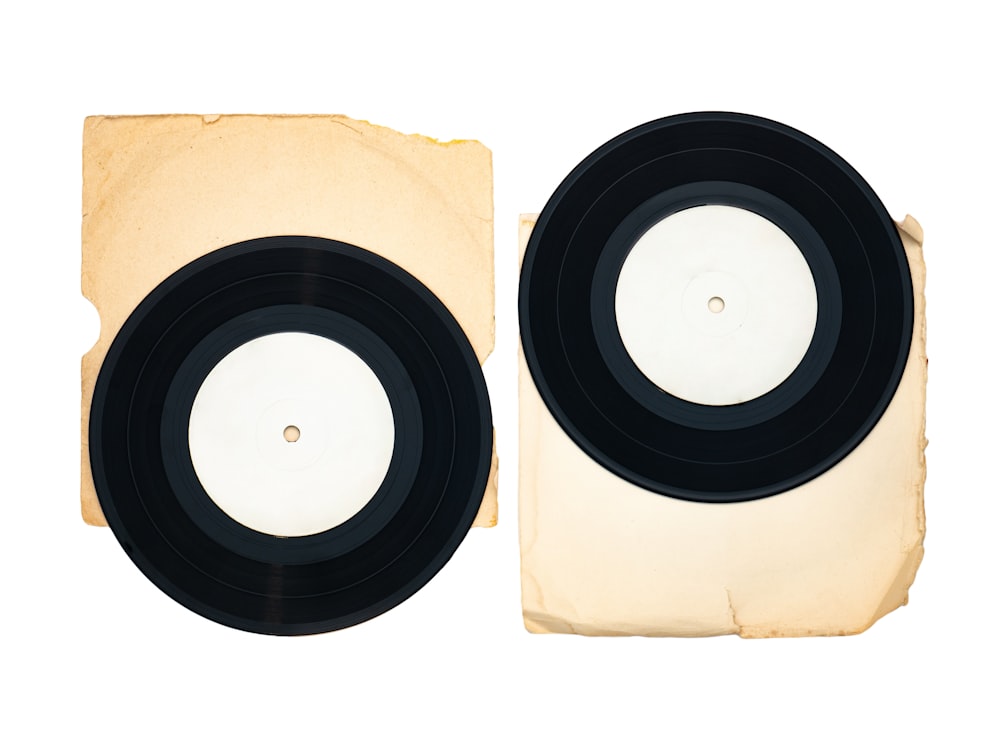 a pair of black and white records sitting on top of a piece of paper