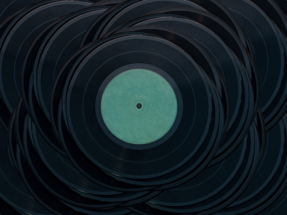a black record with a green disk in the middle of it