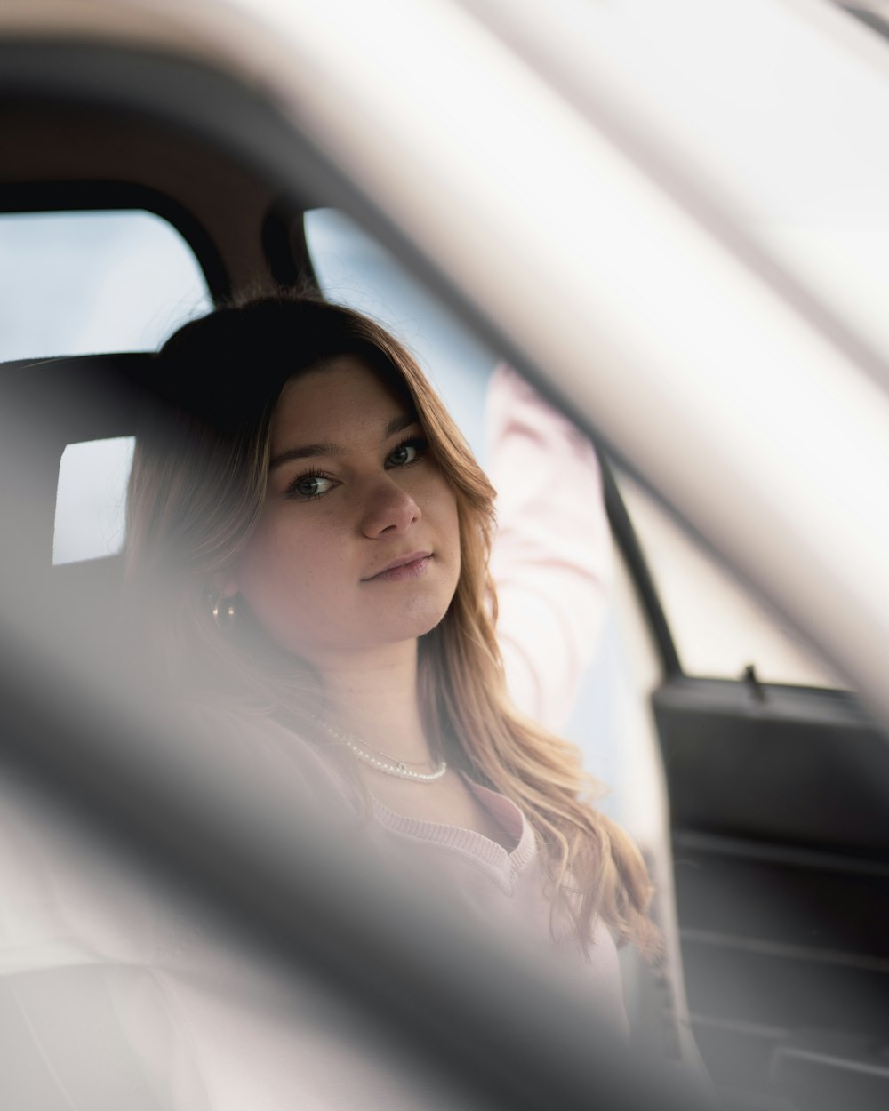 a woman sitting in a car looking out the window