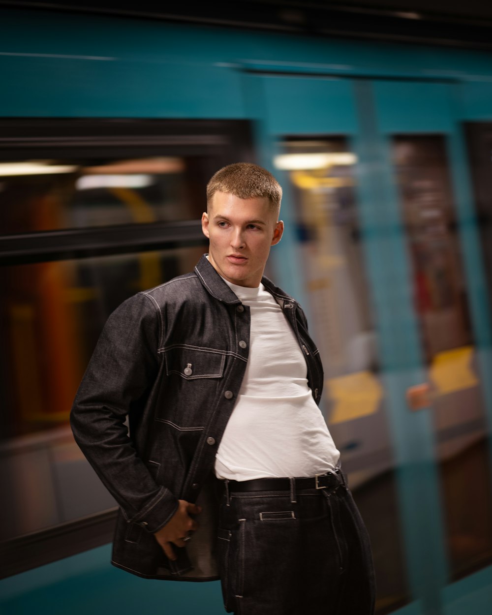 a young man standing in front of a train