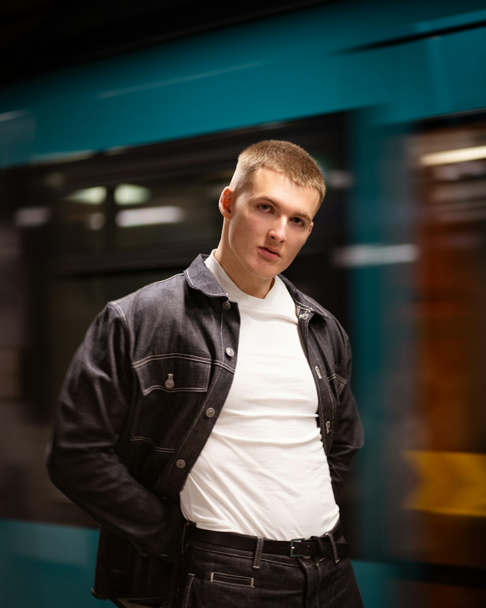 a young man standing in front of a train
