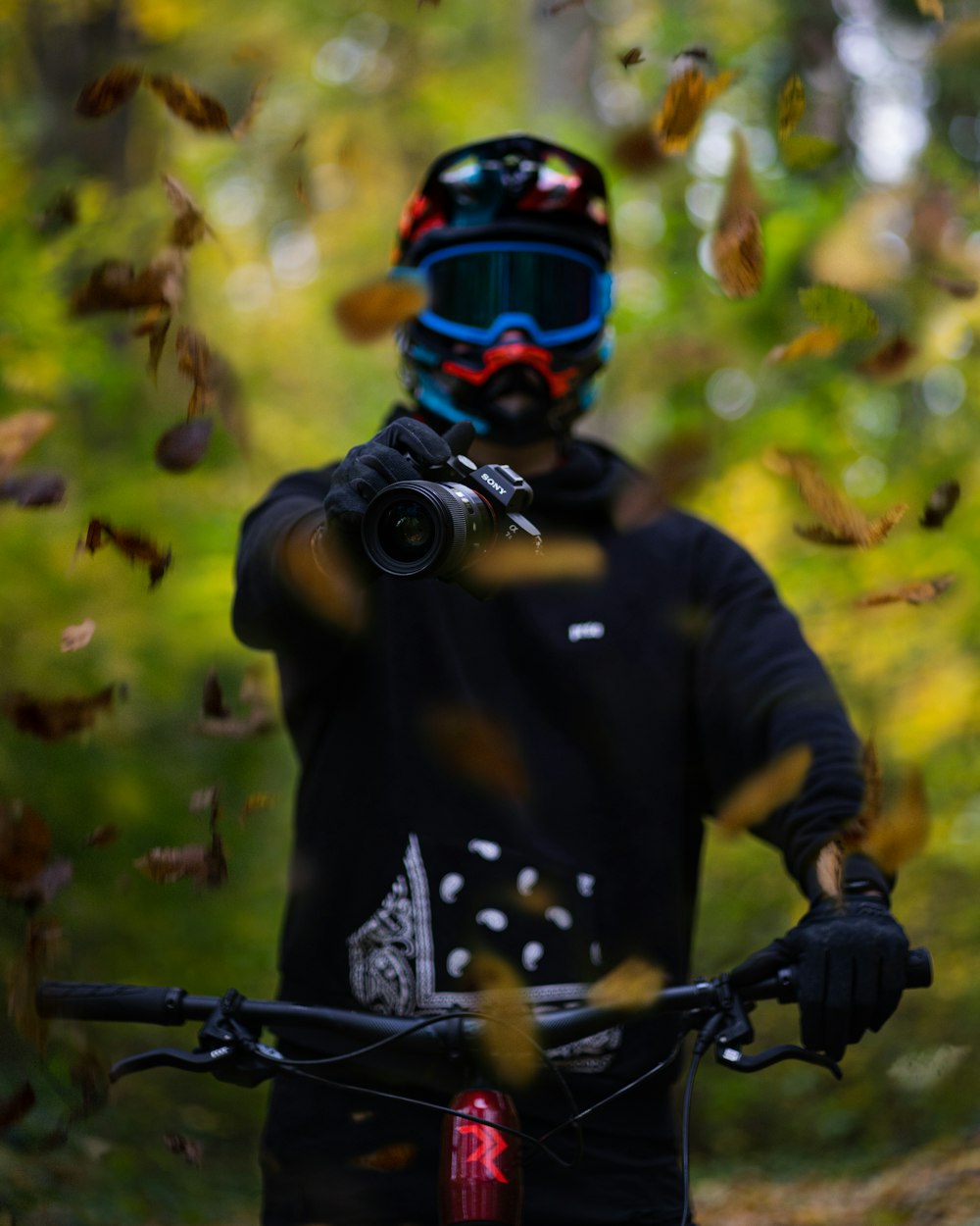 a man riding a bike through a forest filled with leaves
