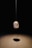 a rock hanging from a string in a dark room