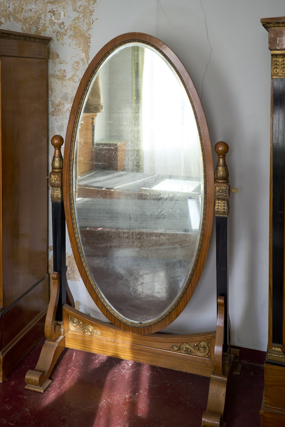 a large round mirror sitting on top of a wooden stand