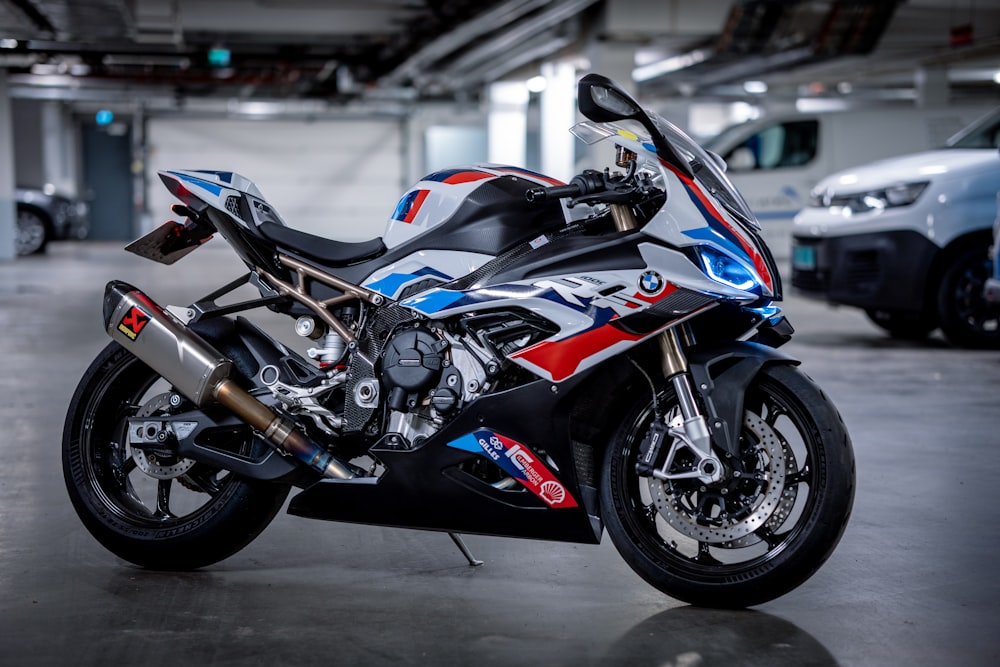 a red, white, and blue motorcycle parked in a garage