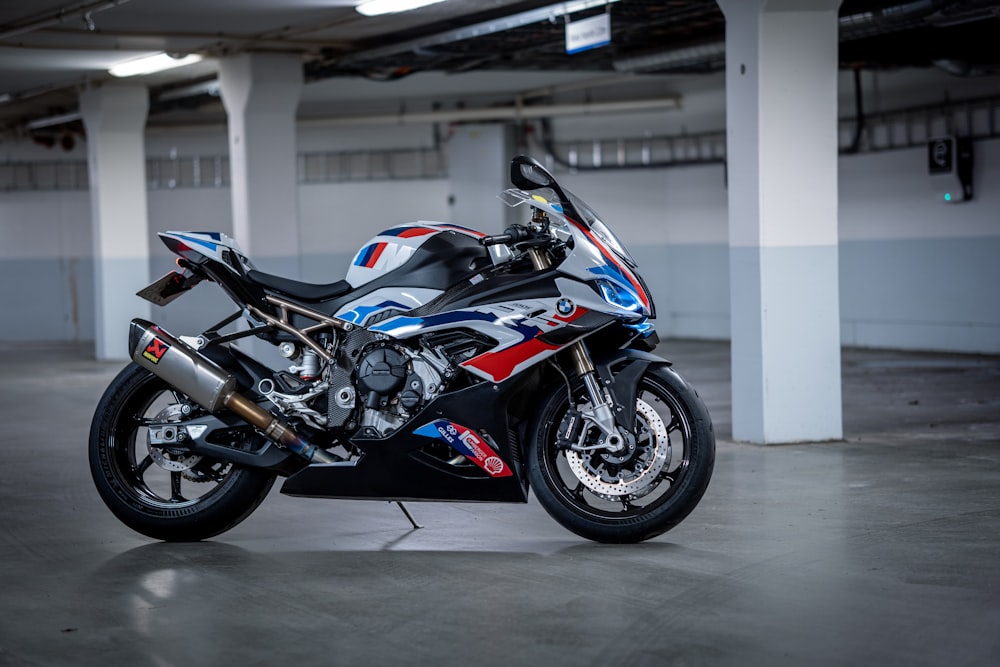 a red, white and blue motorcycle parked in a garage