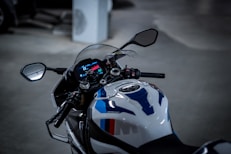 Close-up of a sleek motorcycle dashboard illuminated by soft red lighting.