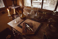 A rustic wooden table with medieval cooking tools and parchment scrolls.