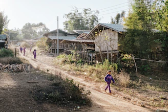 a group of people walking down a dirt road