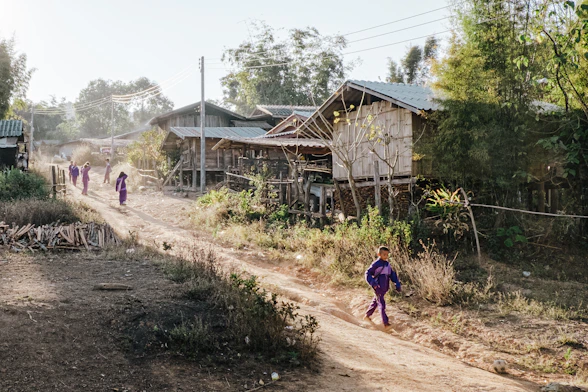 a group of people walking down a dirt road