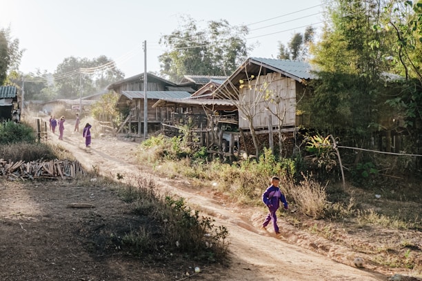 a group of people walking down a dirt road