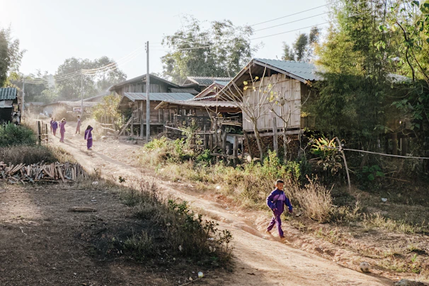 a group of people walking down a dirt road