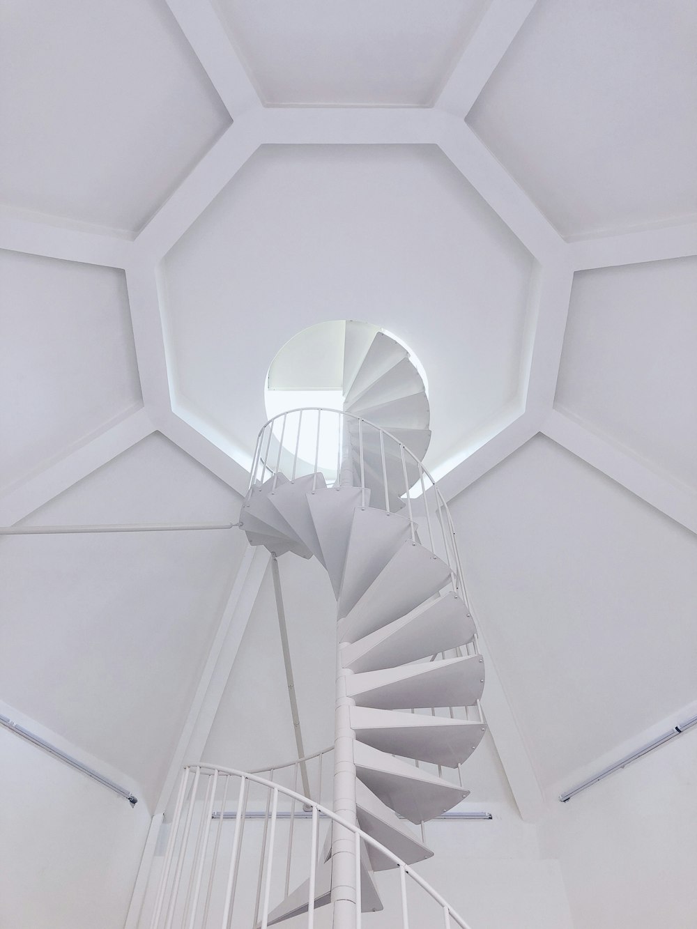 Una escalera de caracol blanca en una habitación blanca