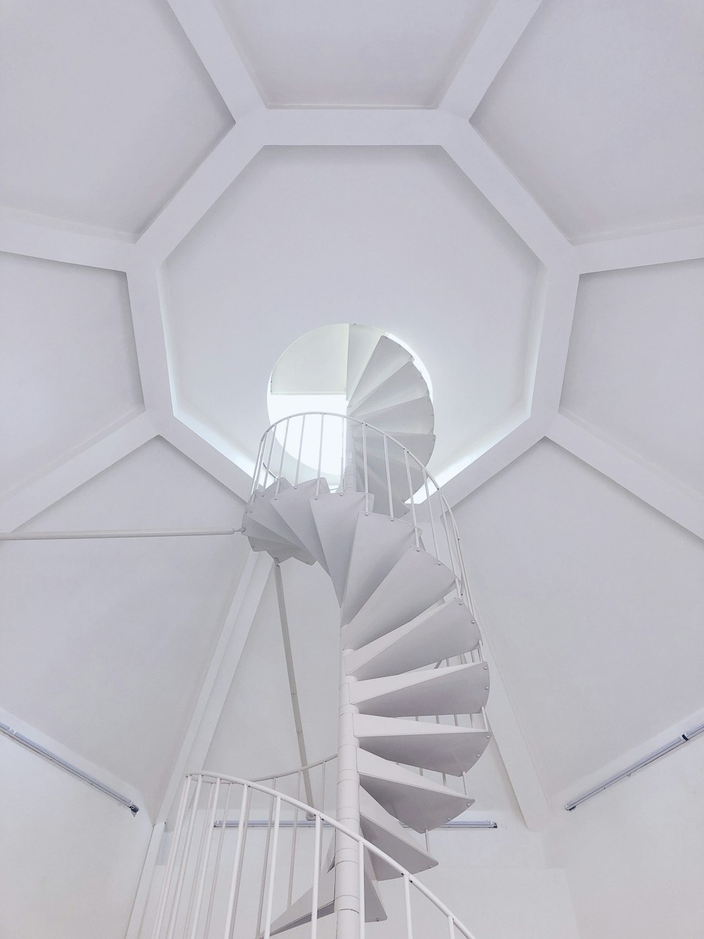 a white spiral staircase in a white room