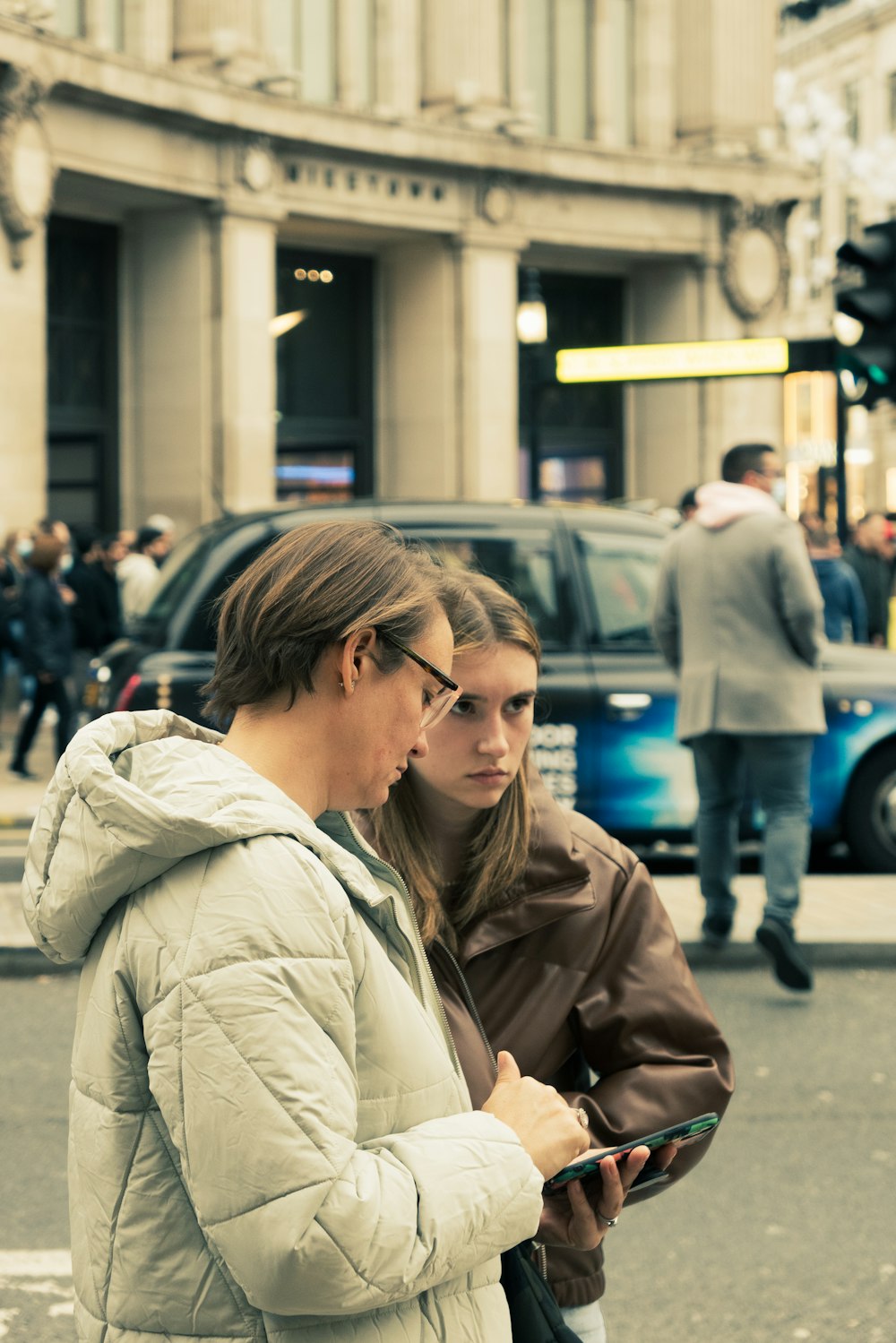 um casal de mulheres de pé um ao lado do outro em uma rua