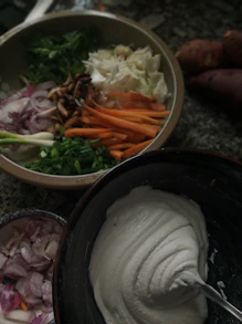 a bowl of vegetables and a bowl of sour cream
