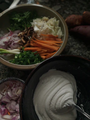 a bowl of vegetables and a bowl of sour cream