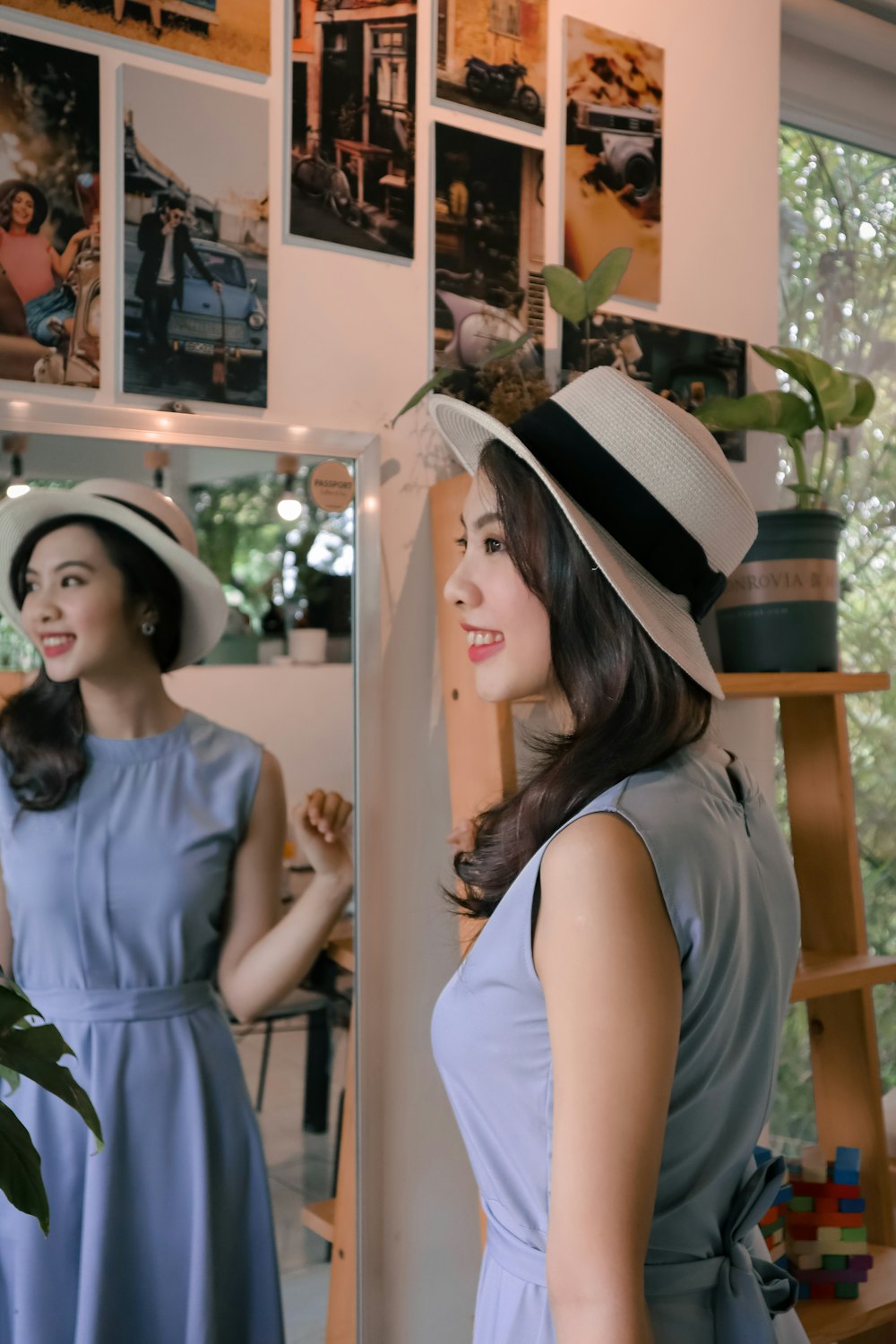 a woman standing in front of a mirror wearing a hat