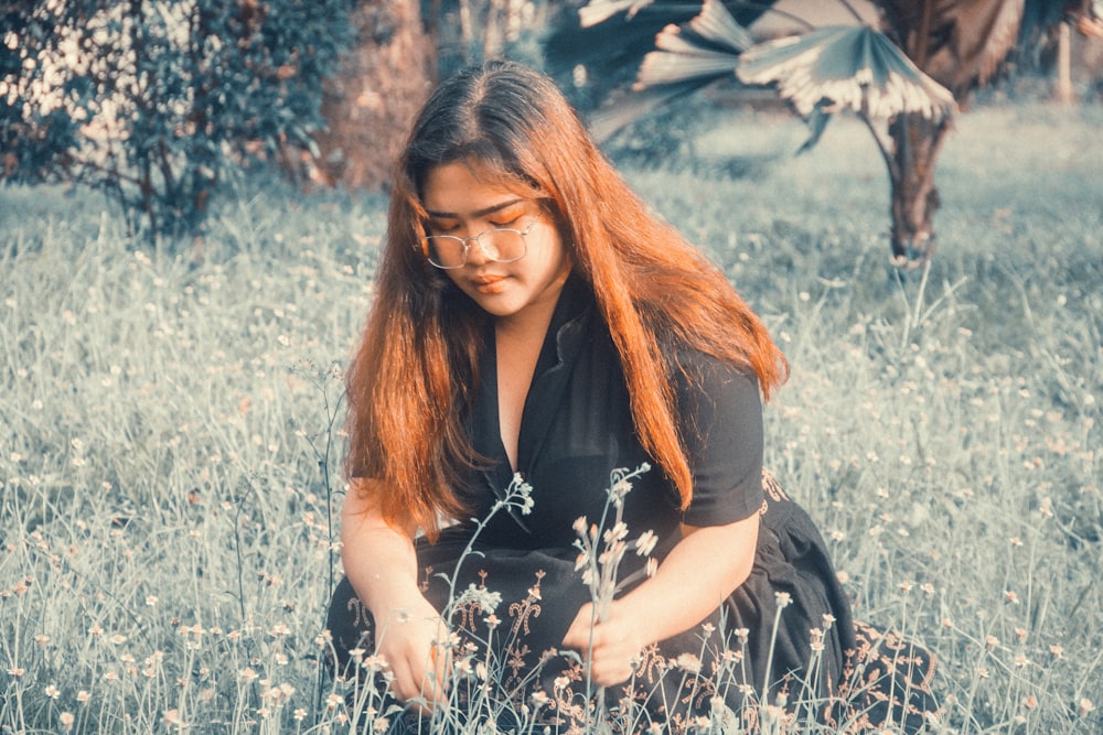 a woman sitting in a field of tall grass