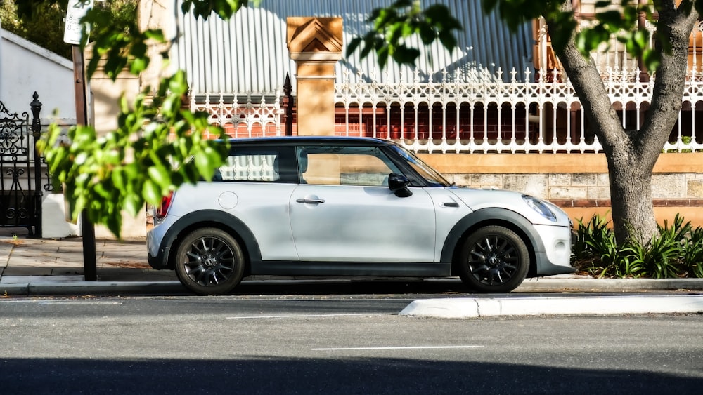 a small white car parked on the side of the road