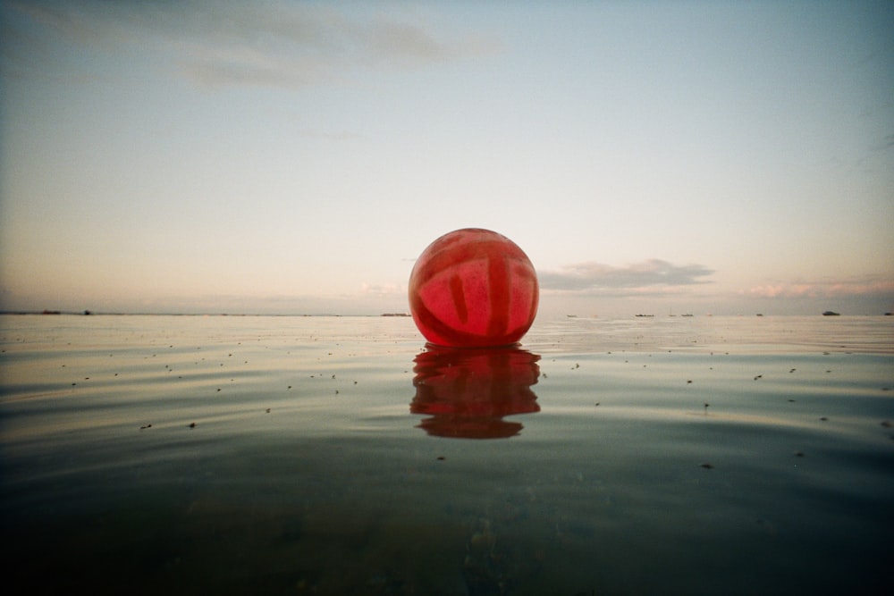 a red ball floating on top of a body of water