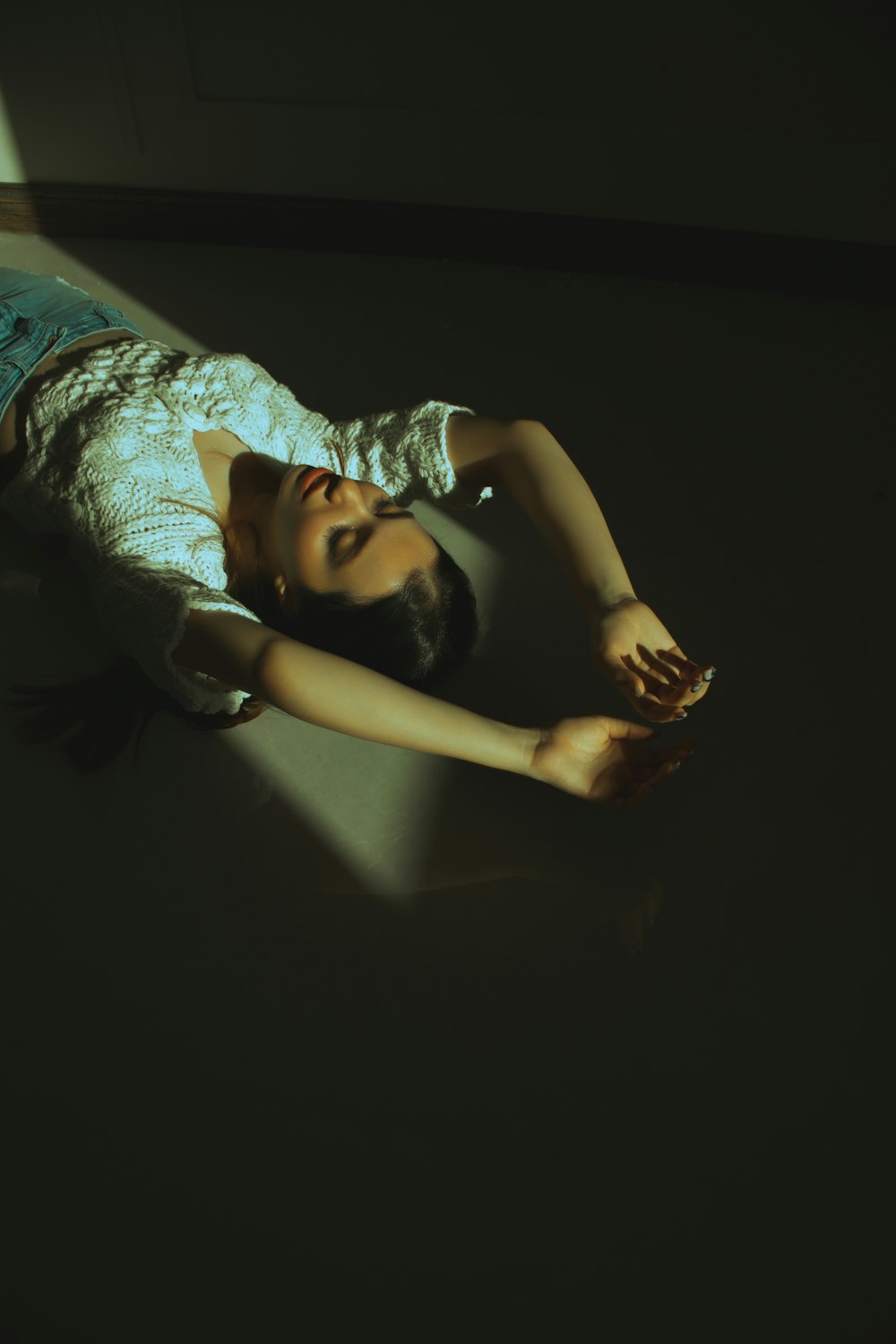 a woman laying on the floor in the dark