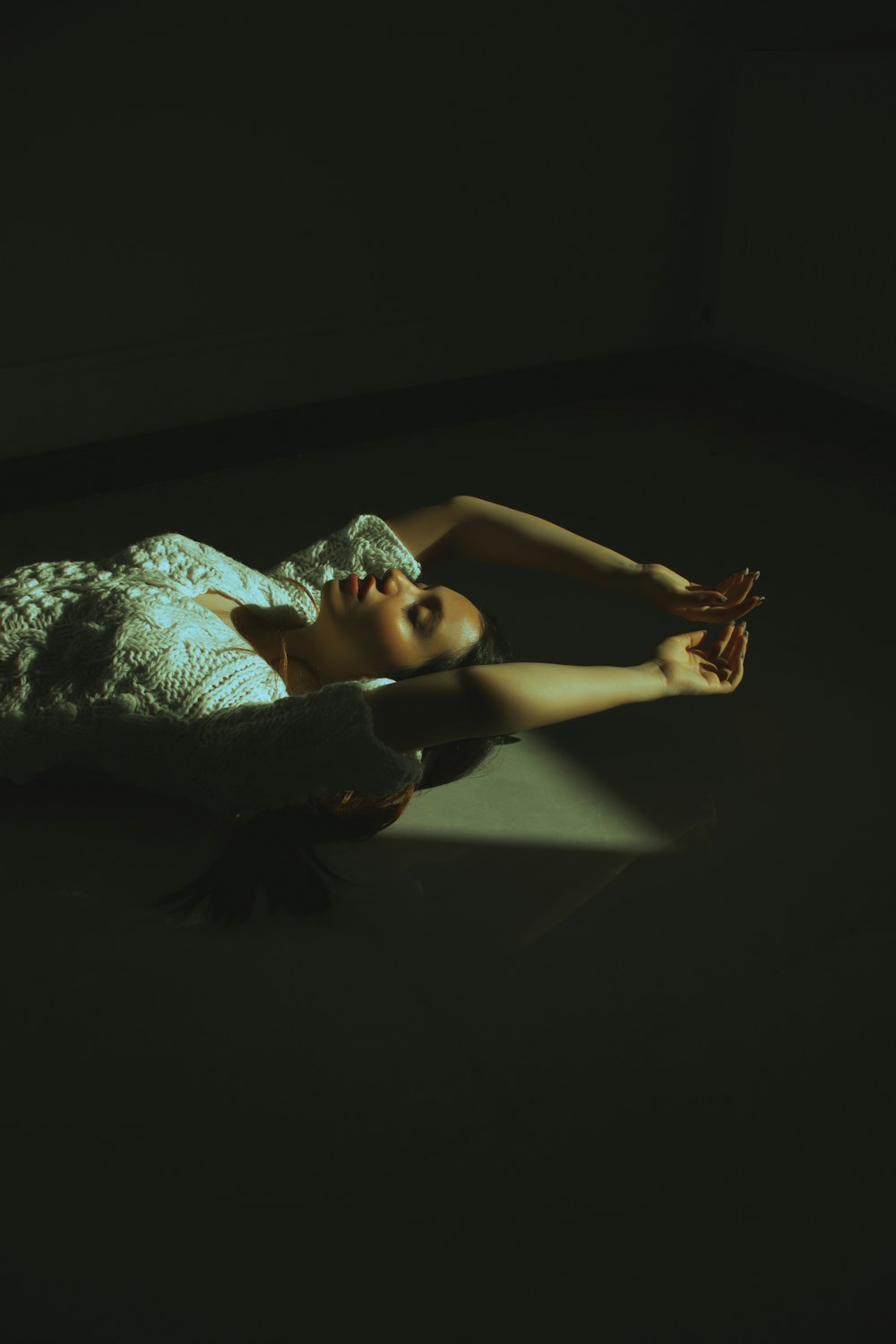 a woman laying on the ground in the dark