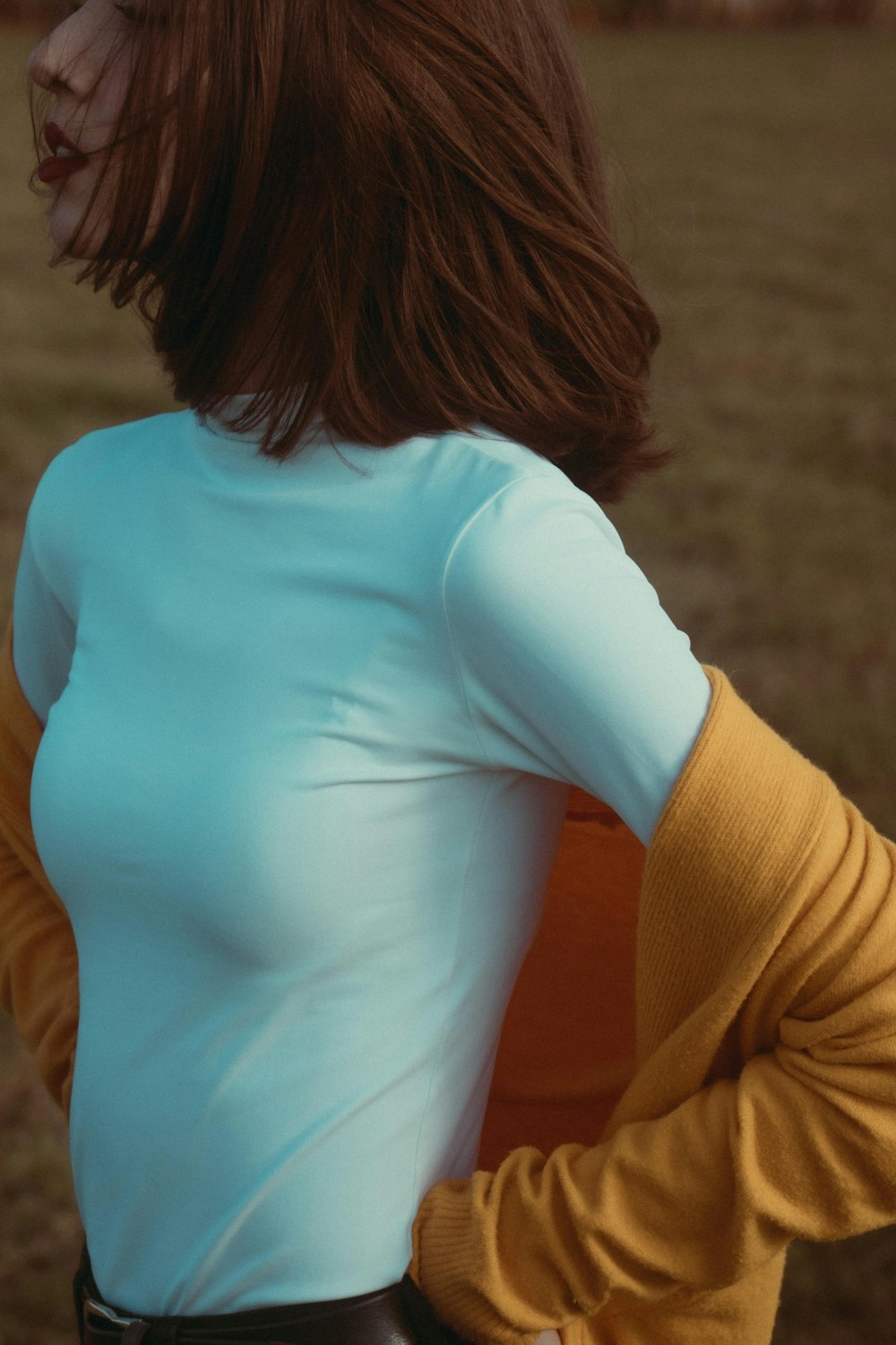 a woman standing in a field with her back to the camera
