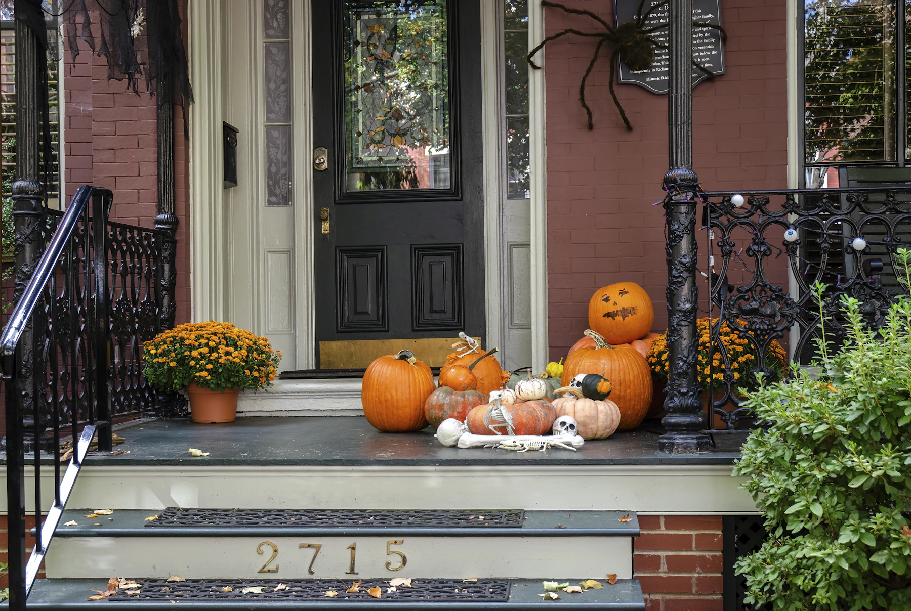 Real front porch with pumpkins, gourds, Halloween decoration and a spider motif