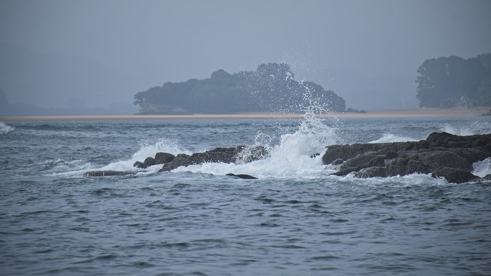 a large body of water with rocks in the foreground
