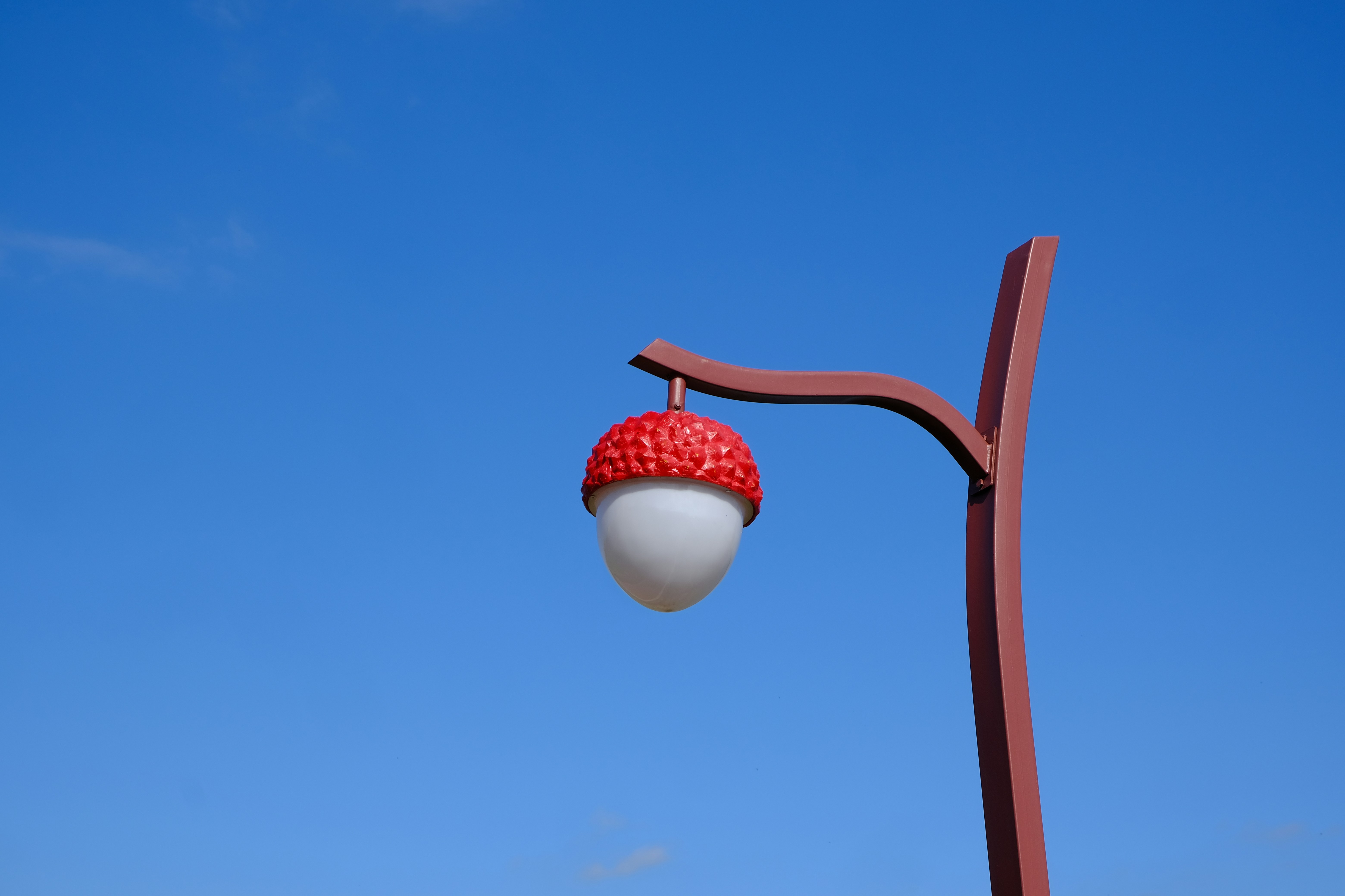 a street light with a strawberry on top of it