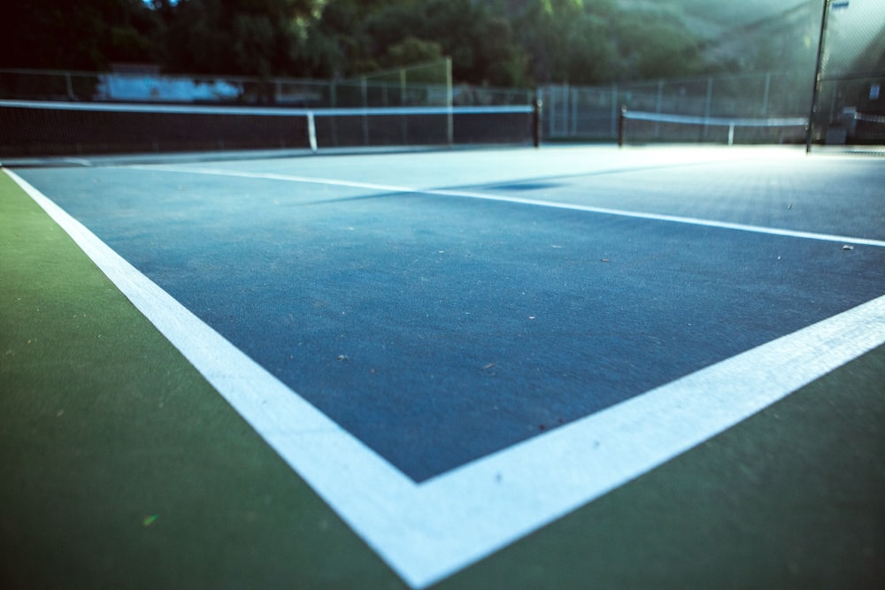 uma quadra de tênis com uma quadra de tênis azul e branca