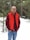 a man standing in the snow wearing a red vest