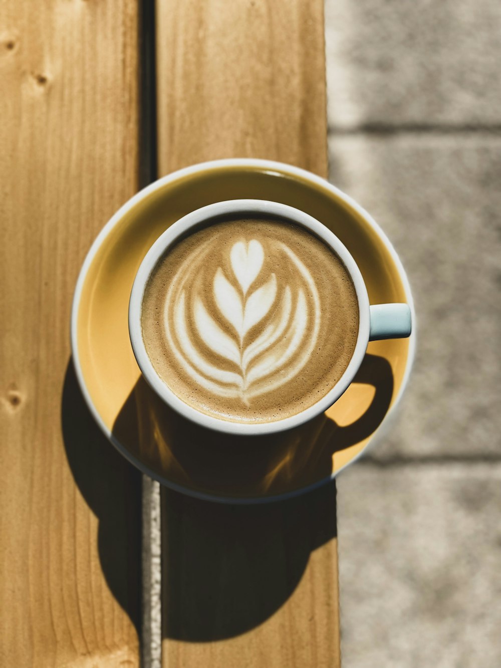 a cup of coffee on a saucer on a wooden table