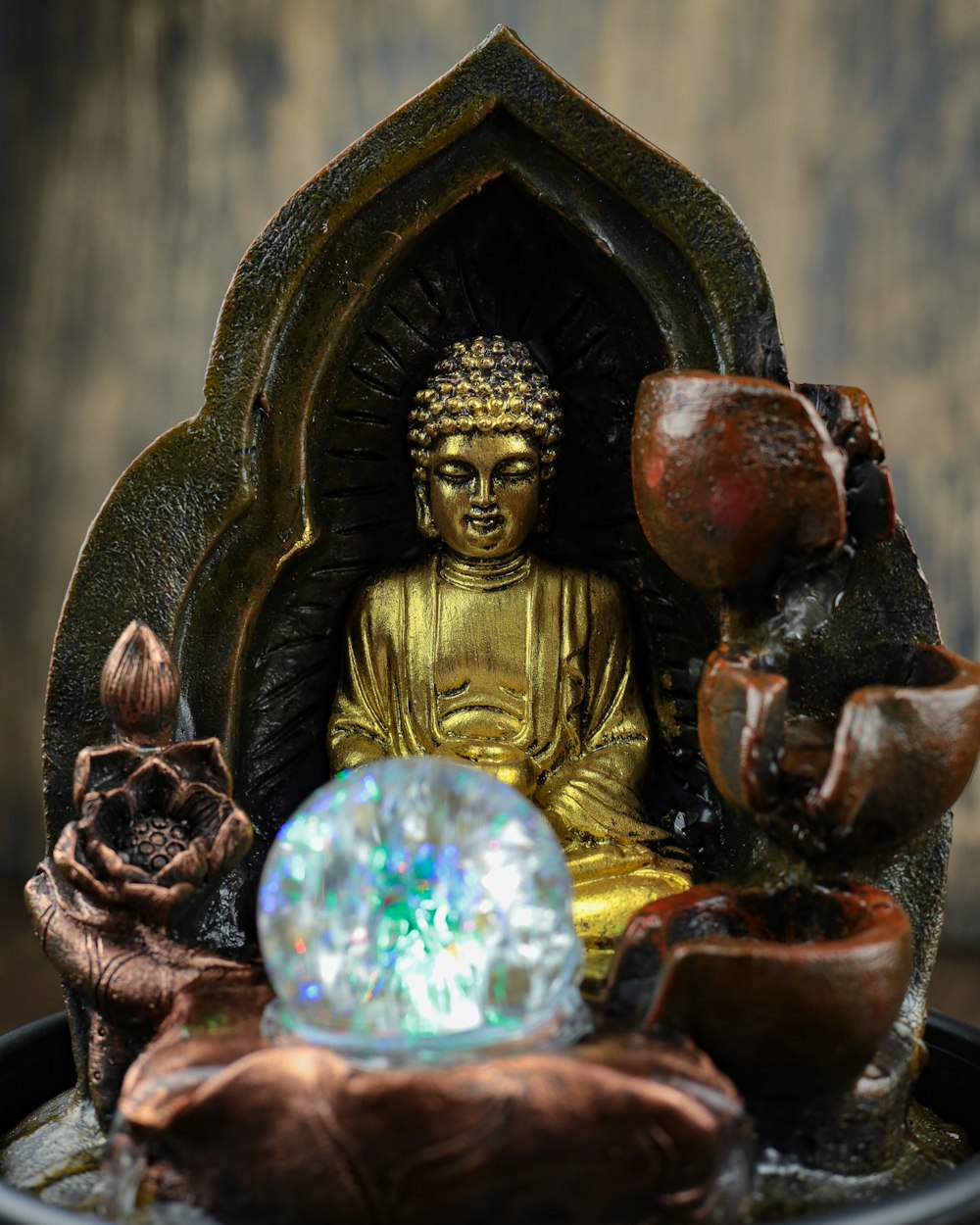 a statue of a buddha sitting in a fountain